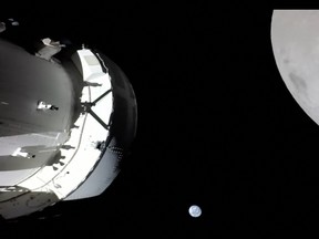This handout image from NASA released on November 21, 2022, shows a view of the spacecraft, the Earth and the Moon captured by a camera on Orion's solar array wing.