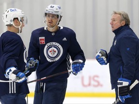 Mark Scheifele (centre), Neal Pionk (left) and head coach Rick Bowness talk things over during Winnipeg Jets practice on Nov. 1.