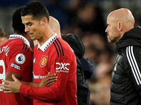 Manchester United's Dutch manager Erik ten Hag (R) watches as Manchester United's Portuguese striker Cristiano Ronaldo (C) is subbed on for Manchester United's French striker Anthony Martial (L) during the English Premier League football match between Everton and Manchester United at Goodison Park in Liverpool, north west England on October 9, 2022.