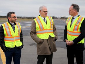 Minister of Transport Omar Alghabra (left), along with Ottawa South MP David McGuinty (right) and the Ottawa Airport CEO, Mark Laroche (centre), were all on hand Monday at the Ottawa airport for the announcement of $4 million from the federal government to rehabilitate taxiways (rear) - much of which has already been completed.