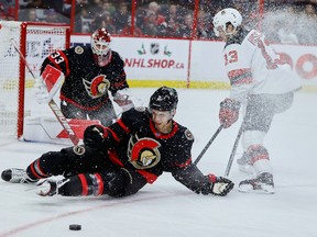 Pemain bertahan Senator Artem Zub memblok tembakan dari tengah Devils Nico Hischier di depan penjaga gawang Cam Talbot selama periode kedua pertandingan hari Sabtu.