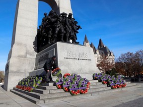 A man lays a wreath ahead of a ceremony at the National War Memorial on Remembrance Day in Ottawa, Nov. 11, 2021.