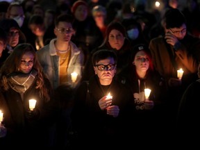 Derek Hill (centre) was amongst about a hundred people who came out for a candlelight vigil at the Human Rights Monument in downtown Ottawa Thursday night to grieve and remember those killed in the recent Club Q shooting in Colorado Springs.