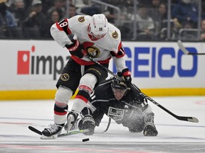 Los Angeles Kings center Anze Kopitar (11) and Ottawa Senators left wing Tim Stutzle (18) battle for the puck in the first period at Crypto.com Arena on November 27, 2022.