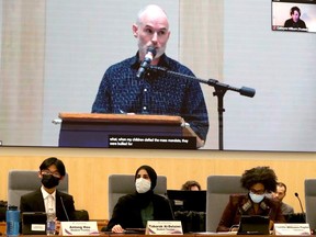 Trustees listen to the first delegate — who was against bringing back a mask mandate — at a meeting on Tuesday. A protest disrupted the meeting which ended without a vote.