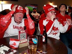 Frances Shields dan temannya Debbie Kirwan, menonton pertandingan di Hometown Sports Grill di Ottawa, menunjukkan kekecewaan mereka setelah skor Belgia di babak pertama Rabu.