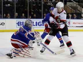 Igor Shesterkin dari Rangers melakukan penyelamatan selama periode pertama di bawah tekanan dari Brady Tkachuk dari Senator.