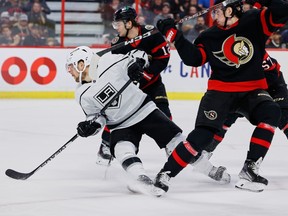 Sayap kanan Senator Ottawa Drake Batherson (19) menggaet sayap kanan Los Angeles Kings Viktor Arvidsson (33) selama periode kedua.