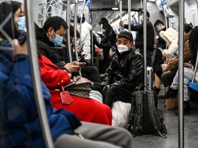 People wear face masks on a train amid the COVID-19 pandemic in Beijing on Dec. 19, 2022.