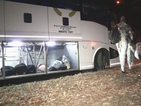 This image provided by WJLA shows migrant families as they get on a bus to transport them from near the U.S. Vice President's residence to an area church after they arrived in Washington, D.C., Saturday, Dec. 24, 2022.