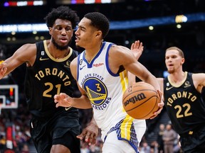 Jordan Poole of the Golden State Warriors drives to the net against Thaddeus Young of the Toronto Raptors on Sunday night at Scotiabank Arena.