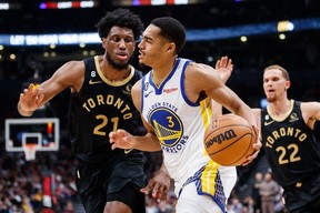 Jordan Poole of the Golden State Warriors drives to the net against Thaddeus Young of the Toronto Raptors on Sunday night at Scotiabank Arena.