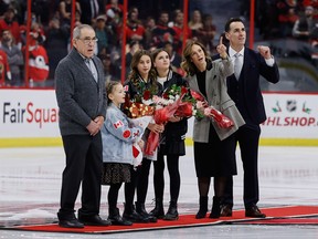 Former Ottawa Senator great Wade Redden (far right) watches his Ring of Honour induction from centre ice with  his wife, Danica (second from right), their three daughters, Lenny, Harper, and Ryann, and his father, Gord Redden, at the Canadian Tire Centre on Monday night.