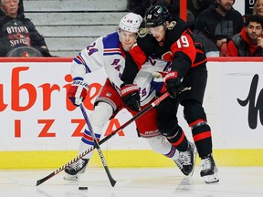 Senators right-winger Drake Batherson (19) battles for a loose puck with Rangers right-winger Kaapo Kakko during the first period of Wednesday's game at Canadian Tire Centre.