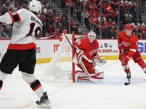 Senators right-winger Drake Batherson banks the puck off Red Wings netminder Ville Husso and into the cage for a goal in tjhe first period of Saturday's game in Detroit.