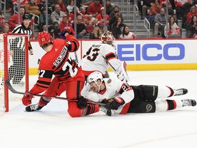 Detroit Red Wings centre Michael Rasmussen (27) gets hooked in front of the Ottawa Senators goal by Ottawa defenceman Travis Hamonic (23) in the second period at Little Caesars Arena, Dec. 31, 2022.