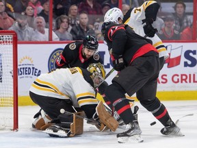 Boston Bruins goalie Jeremy Swayman makes a save in front of the Ottawa Senators' Derick Brassard (61) and Mark Kastelic (47) in the first period at the Canadian Tire Centre on Tuesday night.