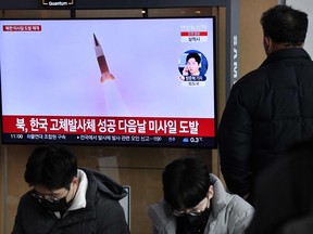 A man watches a television screen showing a news broadcast with file footage of a North Korean missile test, at a railway station in Seoul on Dec. 31, 2022.