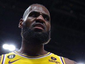 LeBron James of the Los Angeles Lakers reacts after drawing a foul on a basket against Onyeka Okongwu of the Atlanta Hawks during the fourth quarter at State Farm Arena on December 30, 2022 in Atlanta, Georgia.
