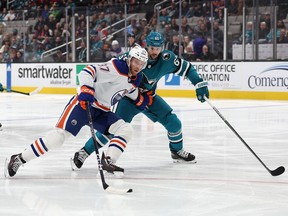 Sharks defenceman Erik Karlsson, right, a former Senators captain, checks Oilers star Connor McDavid in the first period of a game at San Jose on Friday.