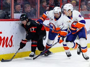 The Ottawa Senators' Ridly Greig (17) keeps the puck away from New York Islanders defenceman Alexander Romanov (28) and centre Jean-Gabriel Pageau (44) during the first period at the Canadian Tire Centre on Wednesday, Jan. 25, 2023.