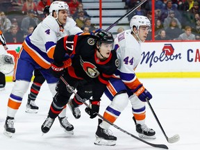 The Ottawa Senators' Ridly Greig battles for position with New York Islanders defenceman Samuel Bolduc (4) and centre Jean-Gabriel Pageau (44) during the first period at the Canadian Tire Centre on Wednesday, Jan. 25, 2023. Greig picked up an assist in his NHL debut.