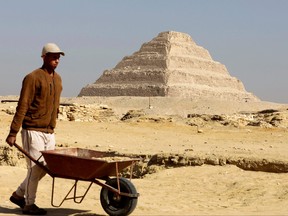 A worker walks in front of the Pyramid of Djoser after the announcement of the discovery of 4,300-year-old sealed tombs in Giza, Egypt, Jan. 26, 2023.