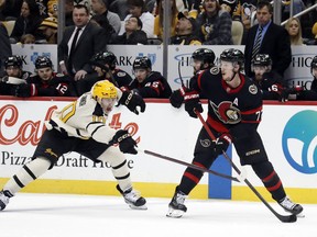 Senators defenceman Thomas Chabot  controls the puck against Penguins winger Drew O'Connor during the first period at PPG Paints Arena.