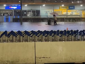 People walk with their luggage at the flooded domestic terminal at Auckland Airport during heavy rainfall in Auckland, New Zealand, Jan. 27, 2023, in this screen grab obtained from a social media video.