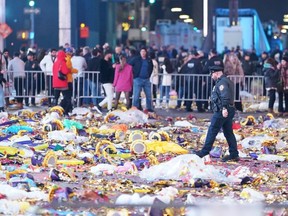 A police officer walks through garbage left behind by revellers at Times Square after the New Year celebrations early Sunday, Jan. 1, 2023 in New York City.