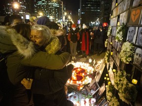 Akram Shojae (second right) is comforted at a vigil in Toronto on Saturday, Jan. 8, 2022 as she mourns her son, Amir Hossein Ovaysi, daughter-in-law Sara Hamzeei and grandchild Asal Ovaysi, who were among the 176 victims of Ukraine International Airlines Flight PS752 that was shot down in Iran in 2020.