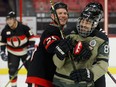 Former Ottawa Senator Chris Neil slows down the Canadian Forces' Bradley Mombourquette during the Soldier On hockey camp Wednesday at the Canadian Tire Centre.