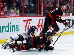Sayap kanan Senator Ottawa Alex DeBrincat (12) dan bek St. Louis Blues Justin Faulk (72) terjerat saat sayap kiri Brady Tkachuk (7) mengikuti permainan selama periode pertama pada Minggu, 19 Februari 2023.