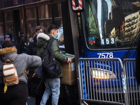 Migrants carry their belongings to a bus after accepting relocation after being evicted from the Watson Hotel on January 30, 2023 in New York City.