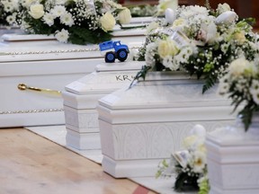 A toy truck is seen as coffins containing people who died in a migrant shipwreck, lie in state at Palasport in Crotone, Italy, Tuesday, Feb. 28, 2023.
