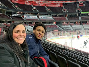 Anthony Allain Samake and his mother, Julie Allain, watch Senators practice on Feb. 9. Allain Samake, who was subjected to racist gestures and words from his teammates in Gatineau last year, will drop the ceremonial first puck Monday as the Senators celebrate Black History Month.