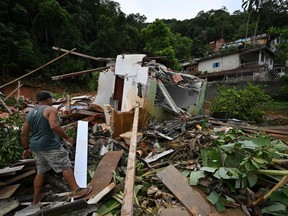 A man walks amid debris at a flood-affected area in the Juquehy district in Sao Sebastiao, Sao Paulo state, Brazil, on Feb. 20, 2023.
