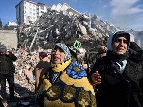 Women react as they wait for a rescue team next to their collapsed building in the southeastern Turkish city of Kahramanmaras, Wednesday, Feb. 8, 2023, two days after a strong earthquake struck the region.