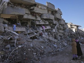 Women check their destroyed building, in Kahramanmaras, Turkey, Wednesday, Feb. 8, 2023.