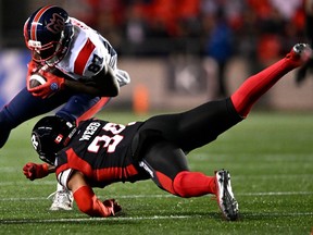 File photo/ Montreal Alouettes wide receiver Eugene Lewis (87) tries to evade the tackle of Ottawa Redblacks defensive back Damon Webb (34).