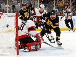 Boston Bruins left wing Jake DeBrusk (74) scores on Ottawa Senators goaltender Kevin Mandolese (70) during the first period at TD Garden.