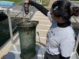 U of T Trash Team member holding up Seabin full of debris.