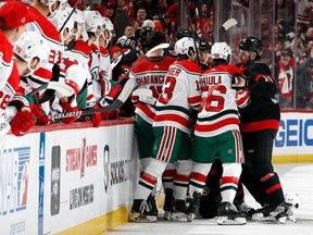 Players get into a scrum near the Senators and Devils benches in the first period.