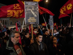 A supporter of the Greek Communist party holds a poster that reads '' it is not an accident it is choice'' in front of the parliament during a protest following the deadly train accident near the city of Larissa, where 57 people, mainly students lost their livee, in Athens on March 4, 2023.