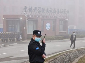 Security personnel stand outside the Wuhan Institute of Virology as members of the World Health Organization team tasked with investigating the origins of COVID-19 arrive for a visit, in Wuhan, China, Feb. 3, 2021.