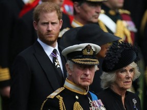 Britain's King Charles III (C), Britain's Camilla, Queen Consort, and Britain's Prince Harry, Duke of Sussex (R).