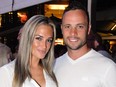 This file photo taken on January 26, 2013 shows South African Paralympian Oscar Pistorius (right) posing next to his girlfriend Reeva Steenkamp at Melrose Arch in Johannesburg.