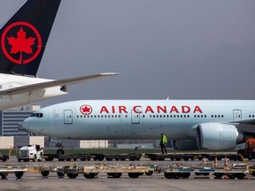 Air Canada planes are seen on the tarmac.