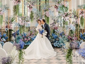 Couple surrounded by flowers during wedding in Casa Lomas conservatory.