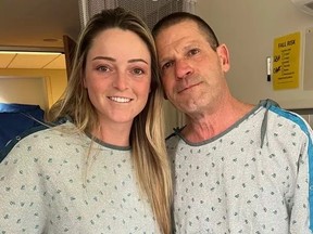 Young woman and father in hospital gowns after kidney transplant.